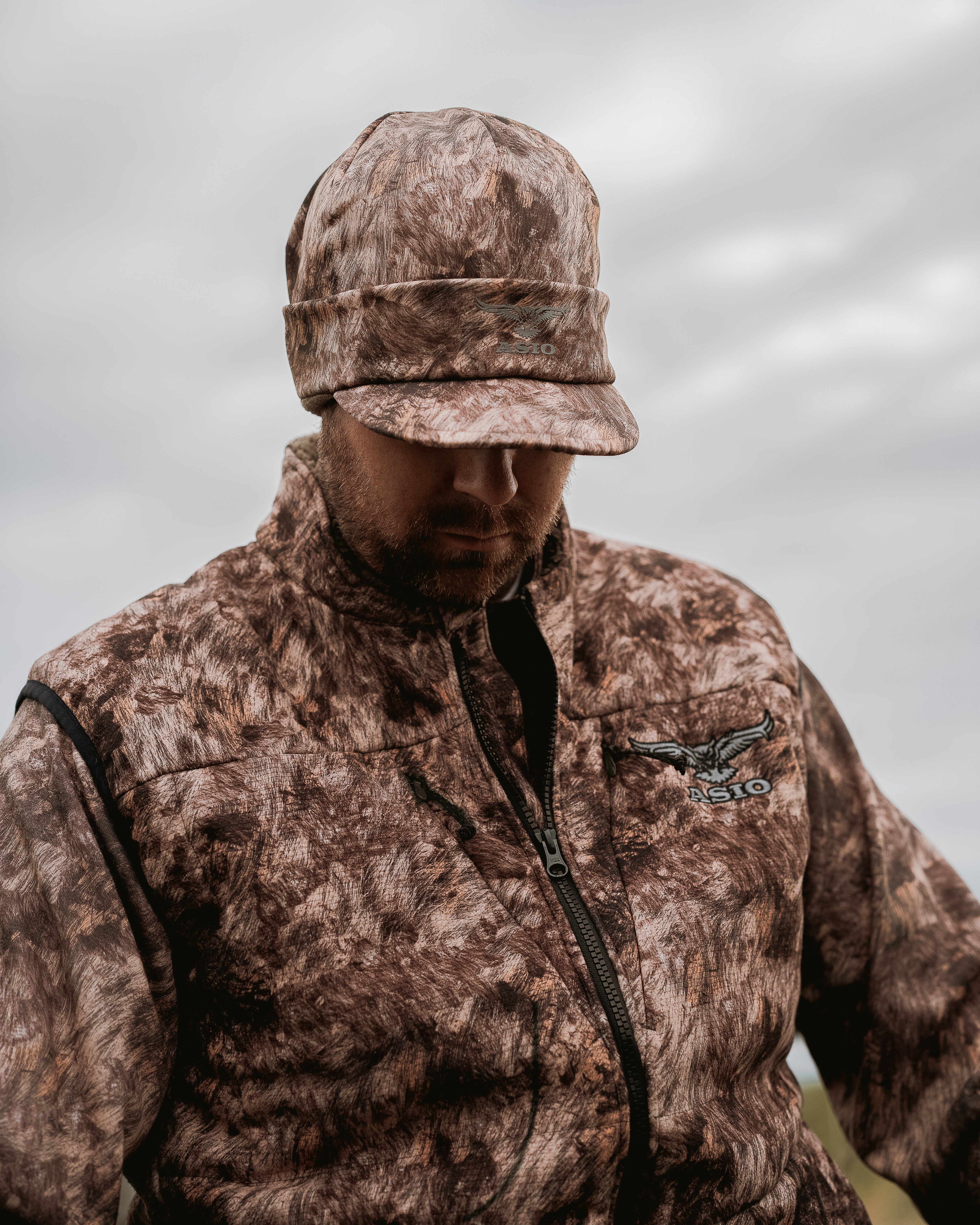 Close-up of ASIO Gear Fleece-Lined Billed Beanie in RAPX CAMO®, designed for cold-weather concealment and comfort during bowhunting missions.