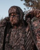 hunter showing off bowhunting collar on raptor camo mid season windproof sherpa hunting jacket