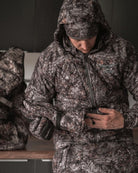 Hunter adjusting ASIO Gear RAPTOR camo heavyweight gloves with full late-season system before field use
